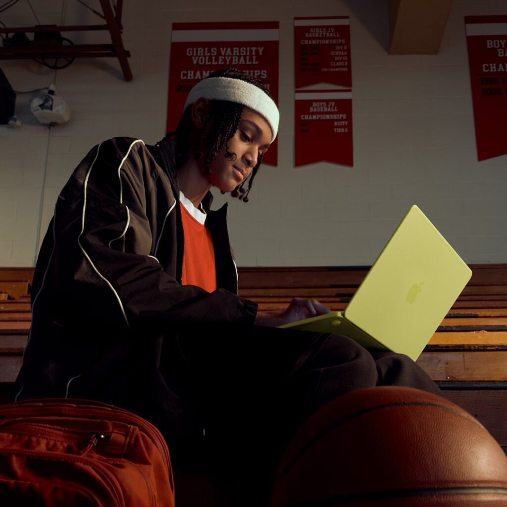 Person using macbook neo on basketball court